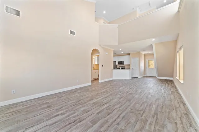 a view of a big room with wooden floor and windows