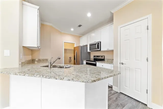 a kitchen with kitchen island granite countertop a stove a sink and a refrigerator