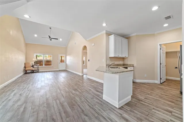 a kitchen with stainless steel appliances granite countertop a stove top oven a sink and a refrigerator