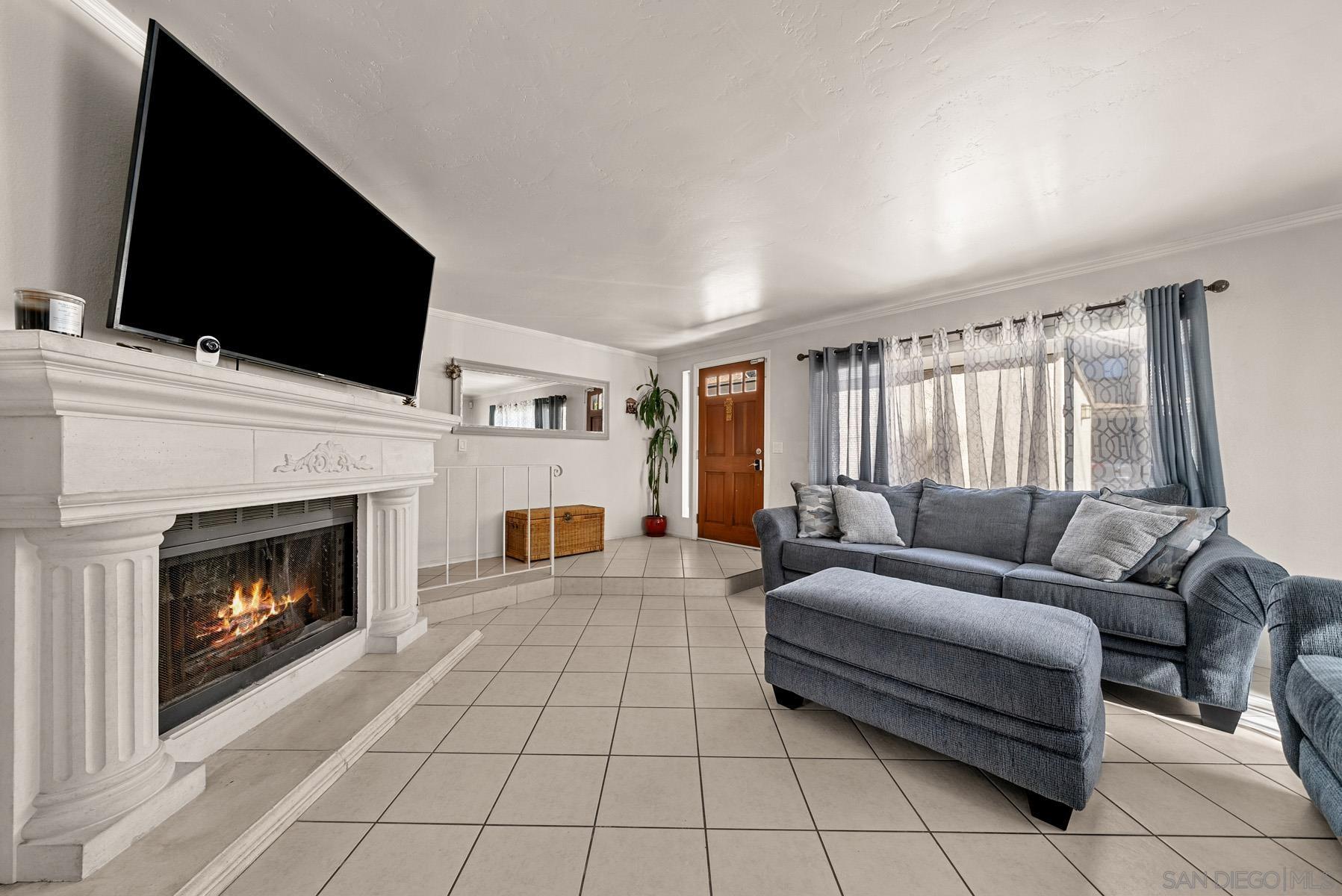 a living room with furniture a flat screen tv and a fireplace
