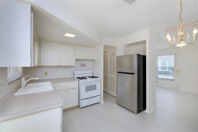 a kitchen with stainless steel appliances a refrigerator sink and stove