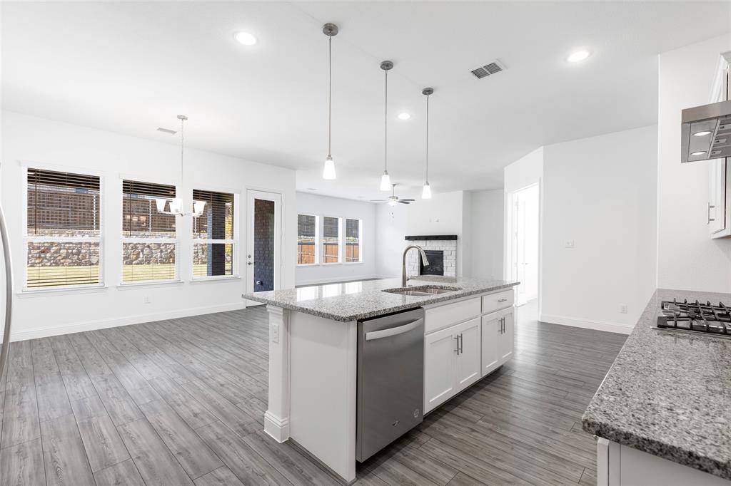 3207 Malcolm Road Melissa, TX 75454 - Photo 11 of 40 a kitchen with stainless steel appliances granite countertop a sink a stove and a wooden floors