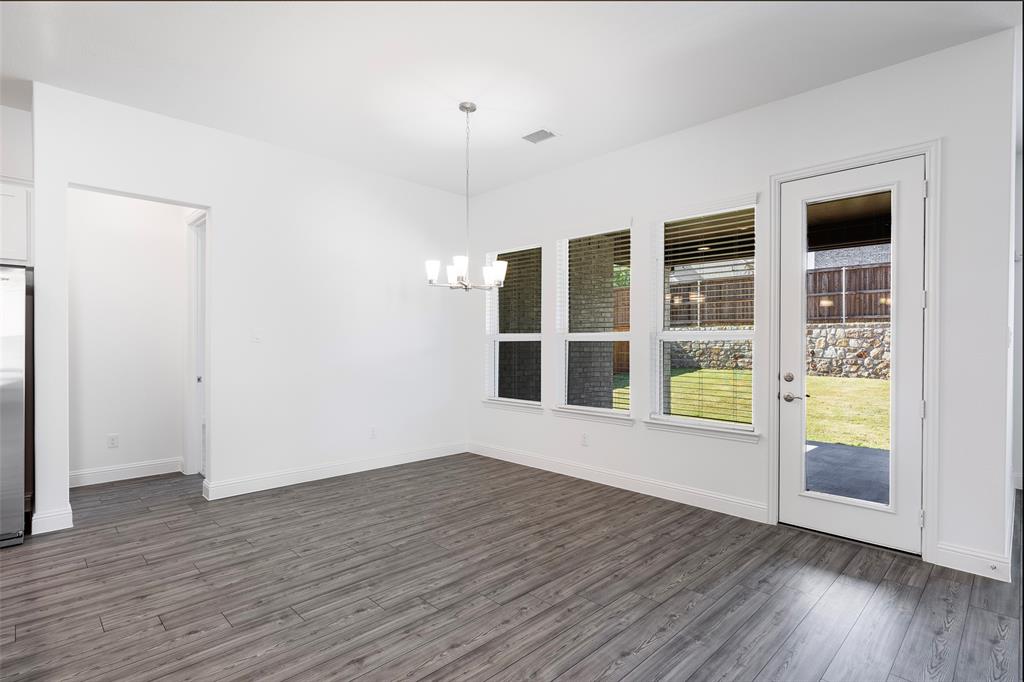 3207 Malcolm Road Melissa, TX 75454 - Photo 12 of 40 a view of an empty room with wooden floor and windows
