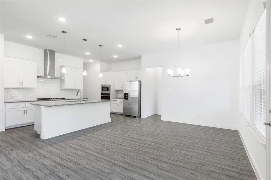 3207 Malcolm Road Melissa, TX 75454 - Photo 13 of 40 a large kitchen with granite countertop a white stove top oven and white cabinets
