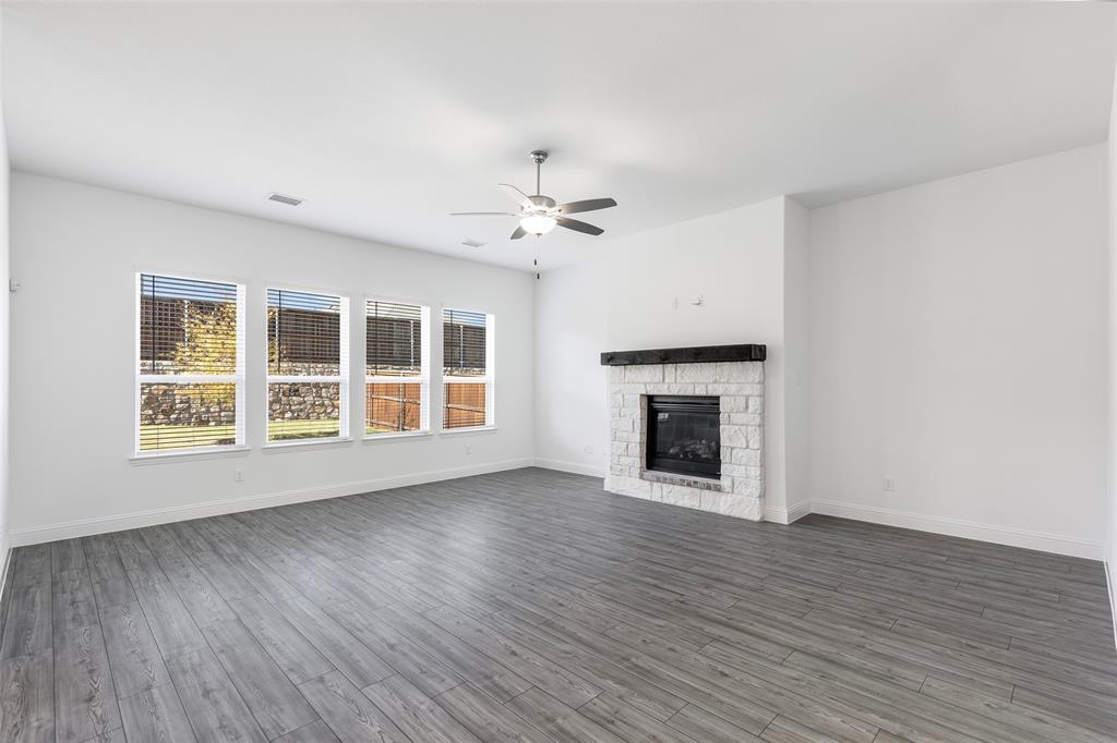 3207 Malcolm Road Melissa, TX 75454 - Photo 15 of 40 a view of an empty room with wooden floor fireplace and a window
