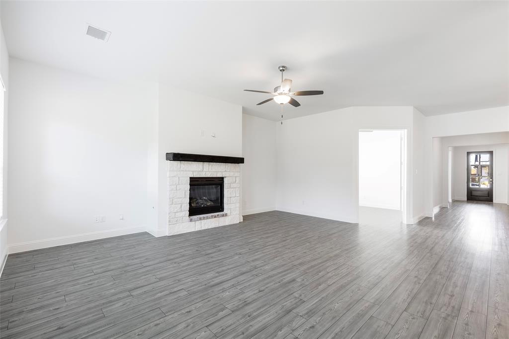 3207 Malcolm Road Melissa, TX 75454 - Photo 16 of 40 a view of an empty room with wooden floor and fireplace