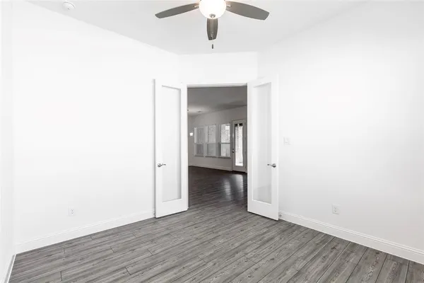 a view of an empty room with wooden floor