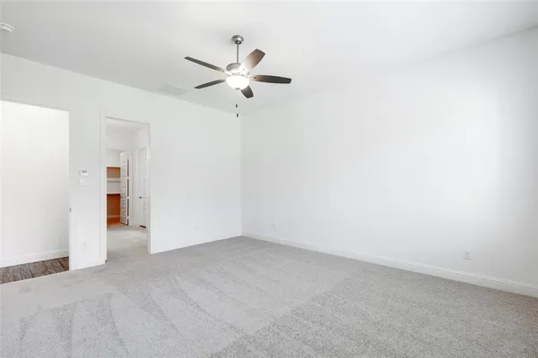 an empty room with a ceiling fan and window