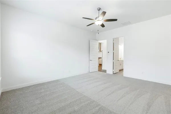 a view of an empty room with a chandelier fan