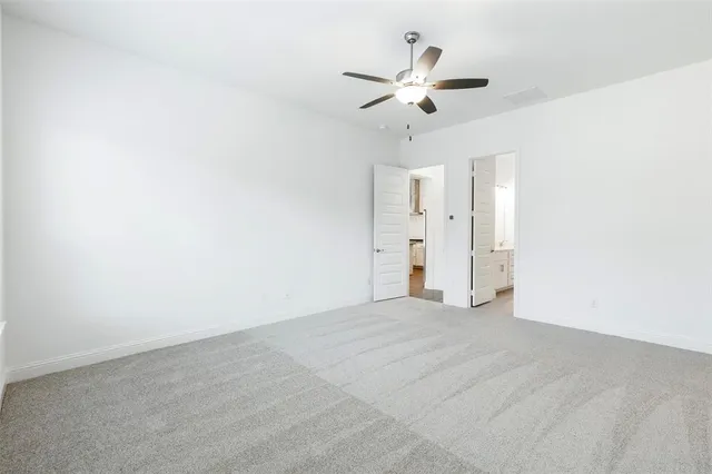 a view of an empty room with a chandelier fan