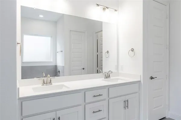 a bathroom with double sink and a mirror