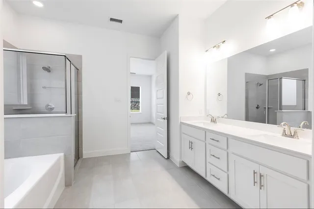 a spacious bathroom with a double vanity sink a mirror and a bathtub