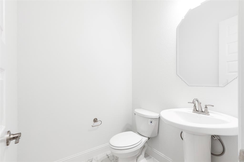 3207 Malcolm Road Melissa, TX 75454 - Photo 33 of 40 a bathroom with a toilet a sink and mirror