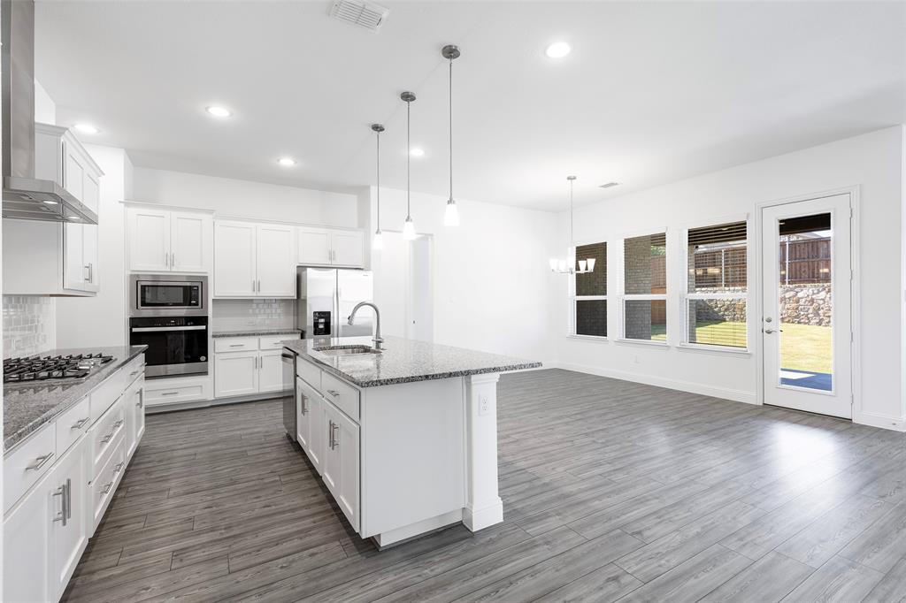 3207 Malcolm Road Melissa, TX 75454 - Photo 6 of 40 a large kitchen with stainless steel appliances granite countertop a stove a sink and a wooden floors