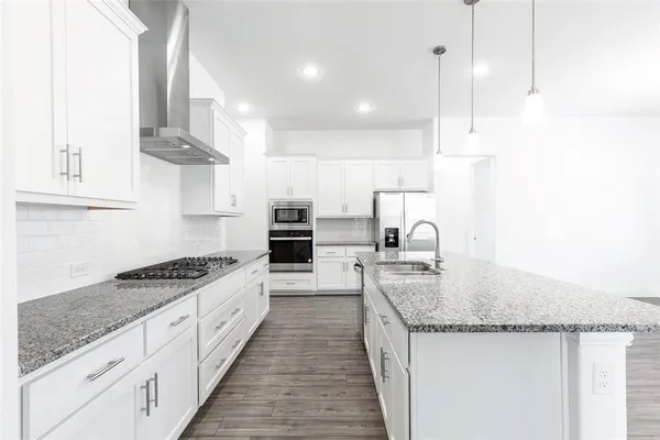a kitchen with stainless steel appliances granite countertop a sink stove and cabinets