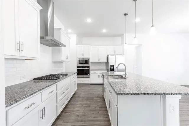 a kitchen with stainless steel appliances granite countertop a sink stove and cabinets