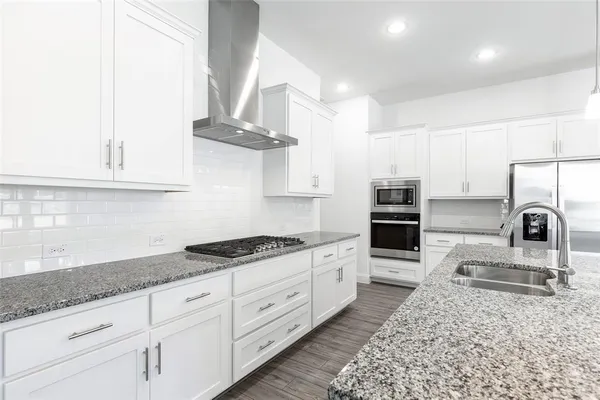 a kitchen with stainless steel appliances granite countertop a sink stove and cabinets