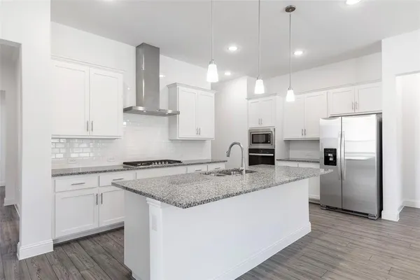 a kitchen with stainless steel appliances granite countertop a sink stove and refrigerator
