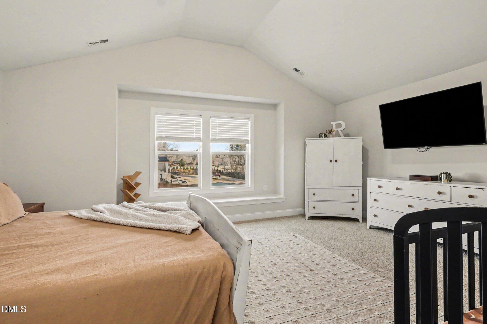 190 Stephens Timberline View Clayton, NC 27520 - Photo 24 of 42 a bedroom with a bed and a flat tv screen on the dresser