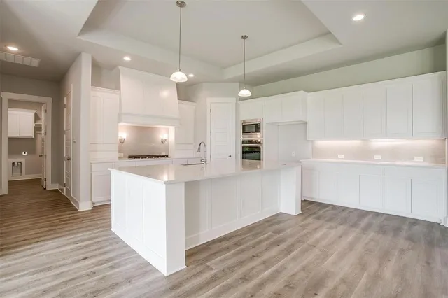 a kitchen with white cabinets and stainless steel appliances