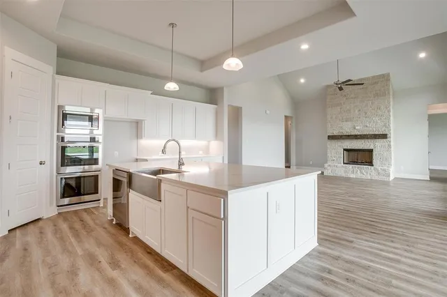 a kitchen with white cabinets and sink