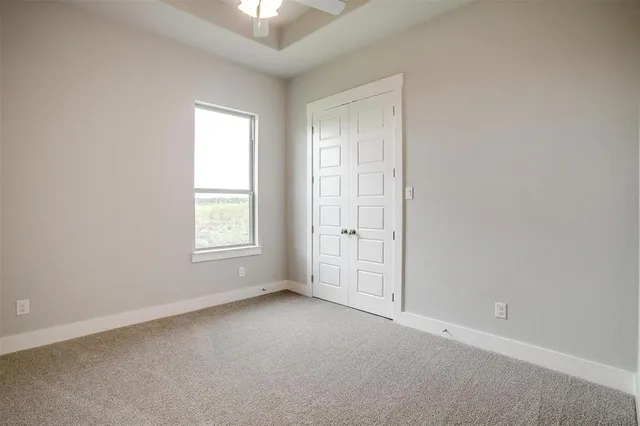 an empty room with windows and closet