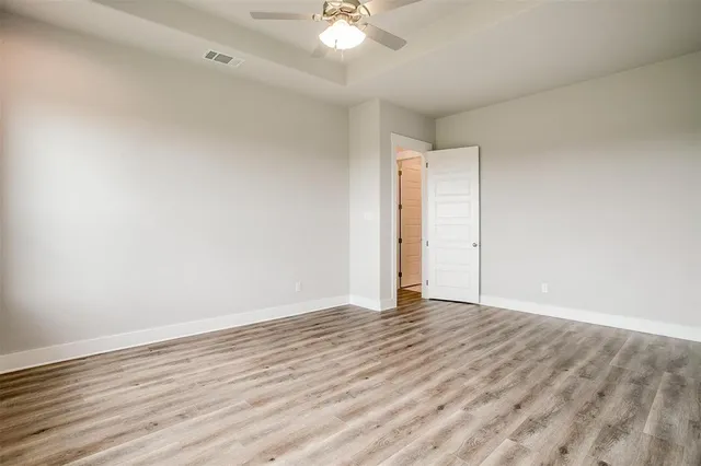 a view of an empty room with wooden floor