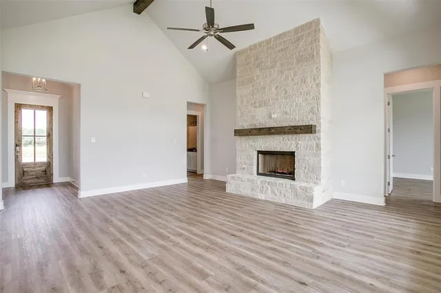 wooden floor fireplace and windows in an empty room