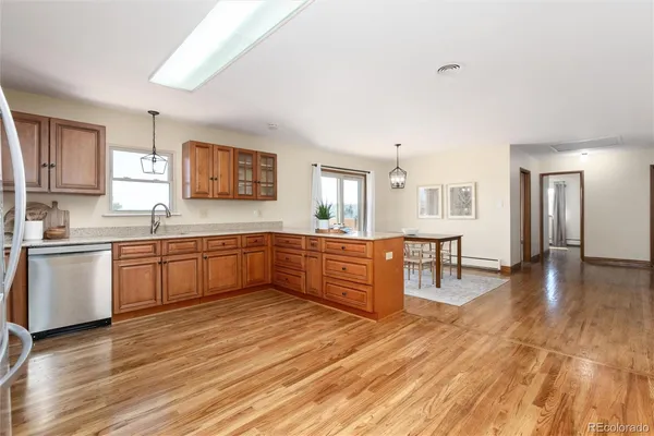 a large kitchen with a wooden floor and large windows
