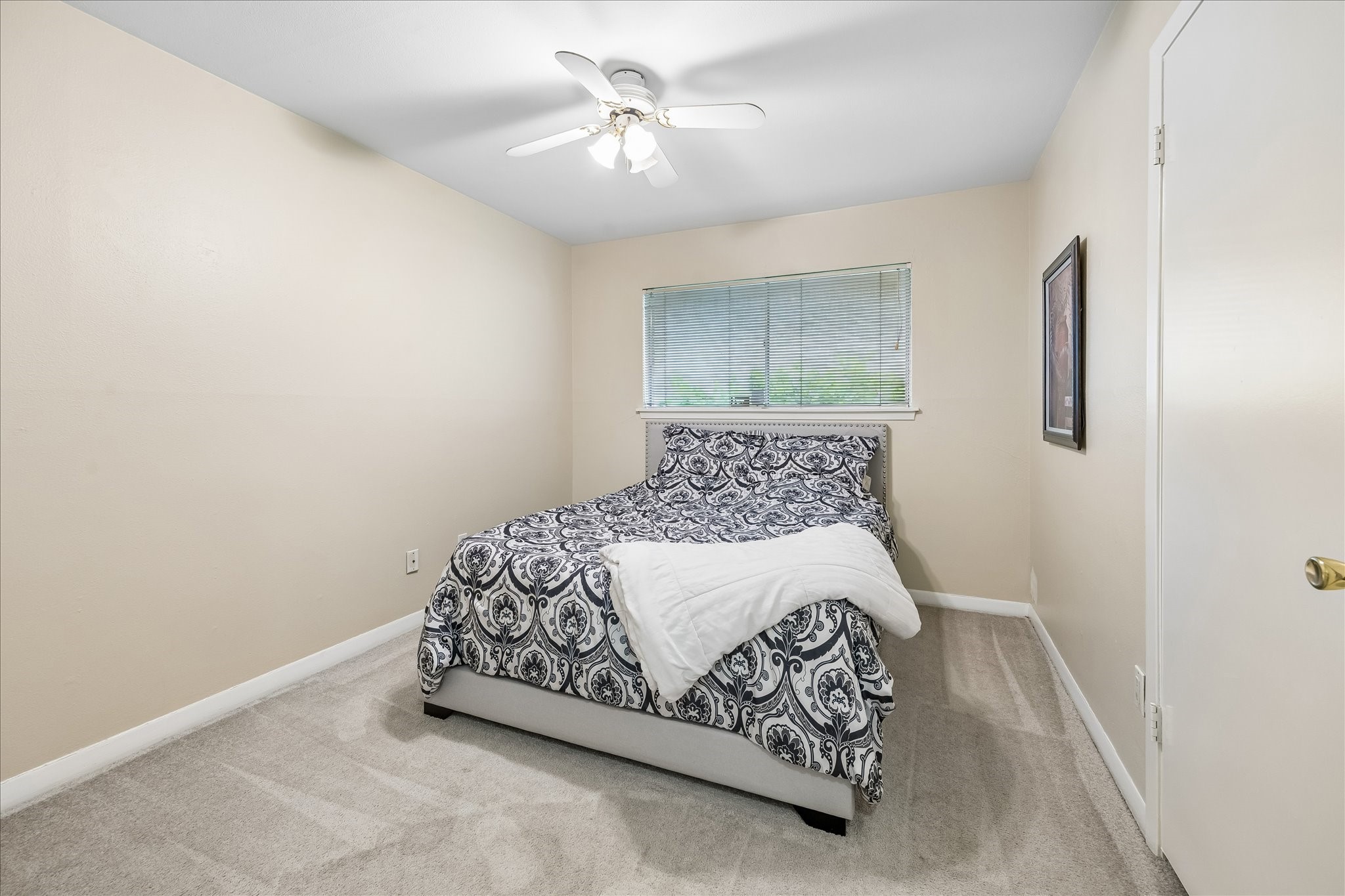 5526 Grape Street Houston, TX 77096 - Photo 7 of 10 a bedroom with a bed and a chandelier