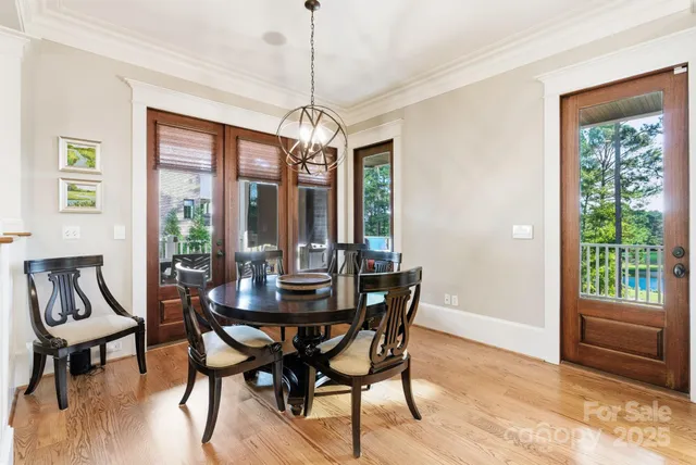 a view of a dining room with furniture a chandelier and wooden floor