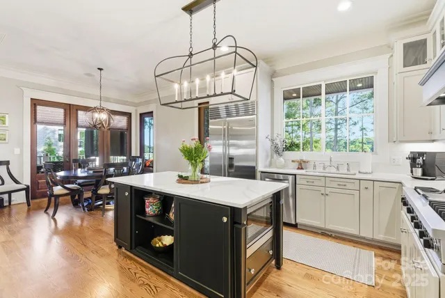 a living room with furniture a flat screen tv and floor to ceiling window