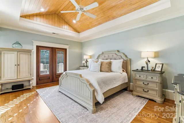 a spacious bedroom with a large bed and wooden floor