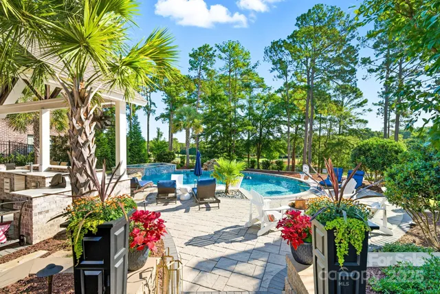 a view of a swimming pool with a patio and a yard