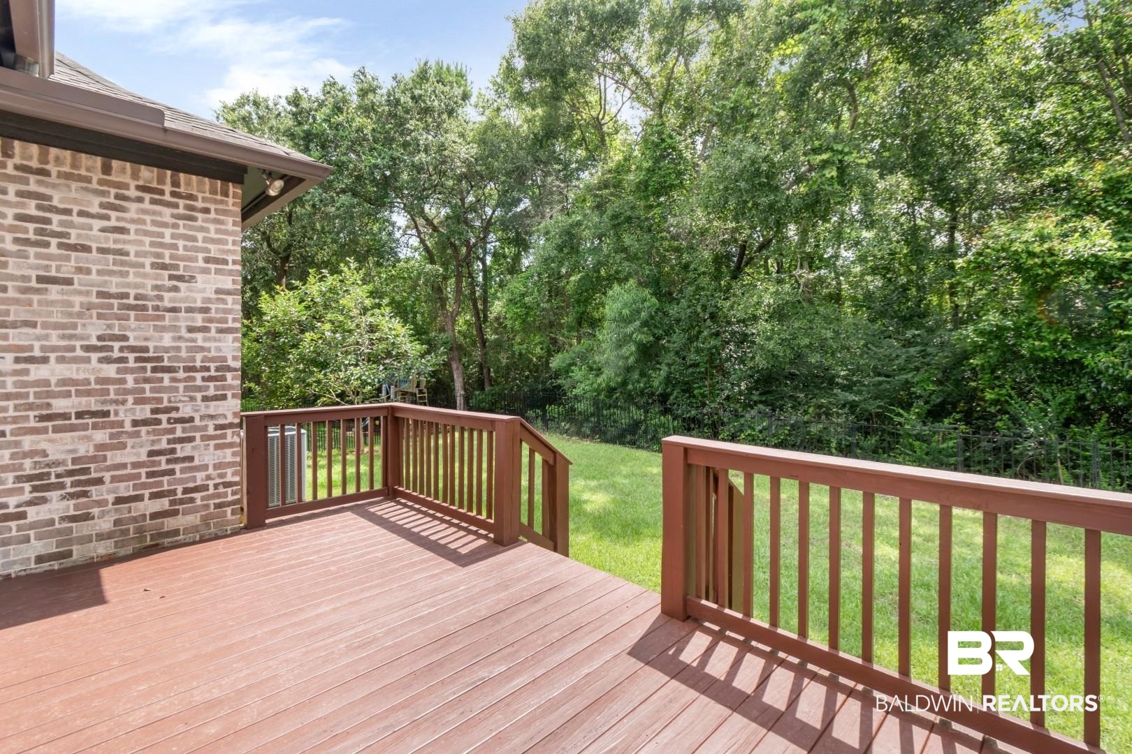 3528 Rue Royal Mobile, AL 36693 - Photo 50 of 53 Expansive outdoor deck with wood-finish railing and a verdant backdrop
