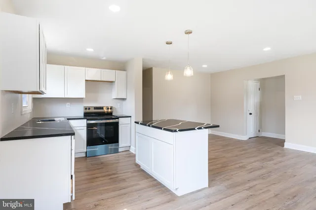 a kitchen with granite countertop a sink and a stove top oven