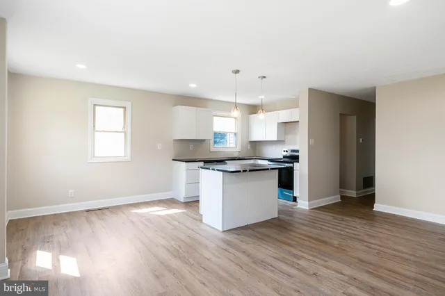 a kitchen with granite countertop a sink cabinets and wooden floor
