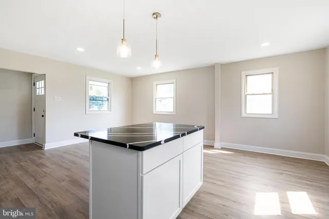 a kitchen that has a sink a window and wooden floor