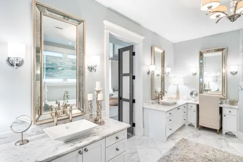 a bedroom with a large bed and a chandelier