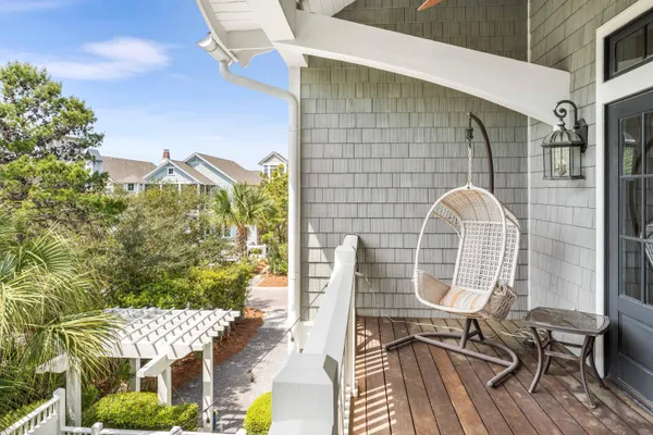 a view of a balcony with chairs and wooden floor