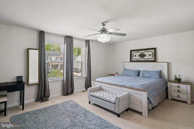 a spacious bedroom with a bed a couch and a chandelier