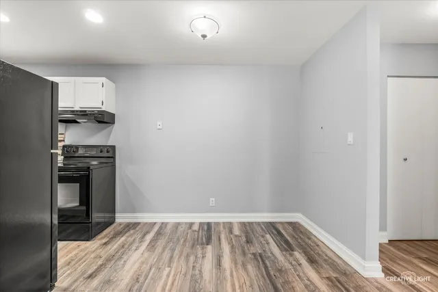 a view of kitchen with wooden floor and electronic appliances