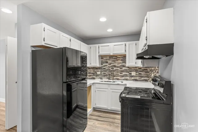 a kitchen with stainless steel appliances granite countertop a stove a refrigerator and a sink