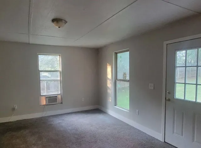an empty room with windows and closet