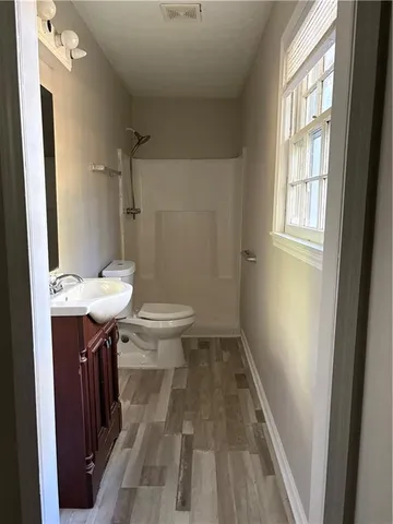 a bathroom with a sink a toilet a mirror and shower