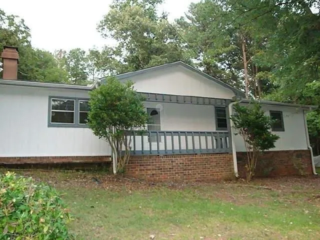 a view of a house with a yard and large tree
