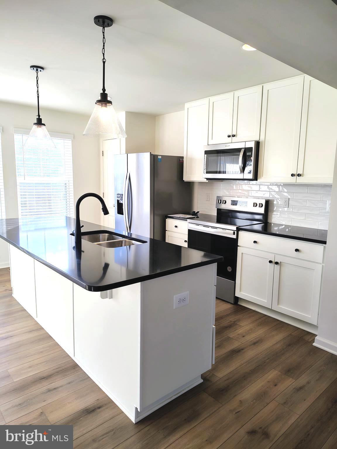 136 Tuxford Road Falling Waters, WV 25419 - Photo 8 of 27 a kitchen with stainless steel appliances granite countertop a sink a stove a refrigerator and white cabinets