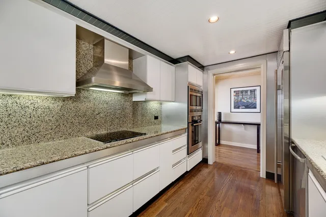 a kitchen with granite countertop a refrigerator and a sink