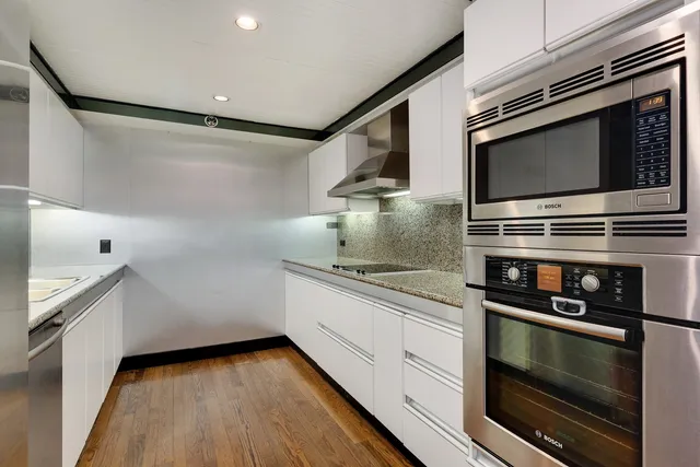 a kitchen with stainless steel appliances a stove microwave and sink