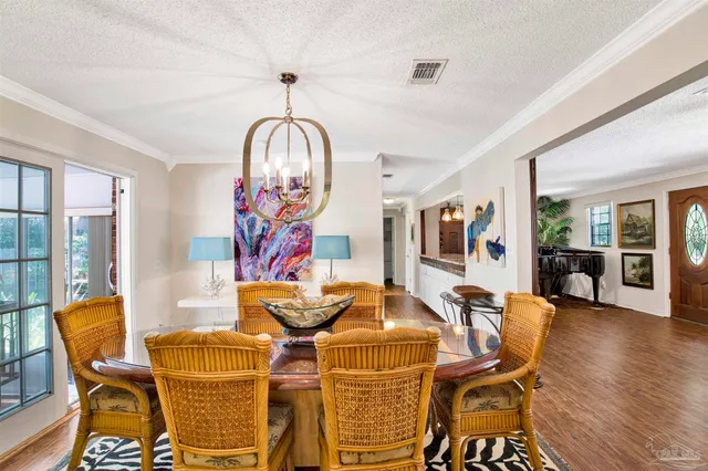 a view of a dining room with furniture wooden floor and chandelier